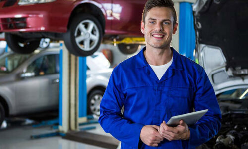 Portrait of mechanic holding digital tablet at repair garage